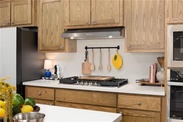 a kitchen with stainless steel appliances granite countertop a sink stove and cabinets