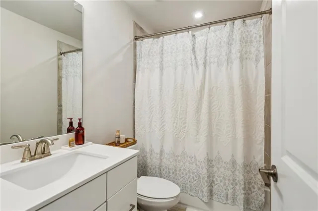 a bathroom with a sink a toilet and shower curtain