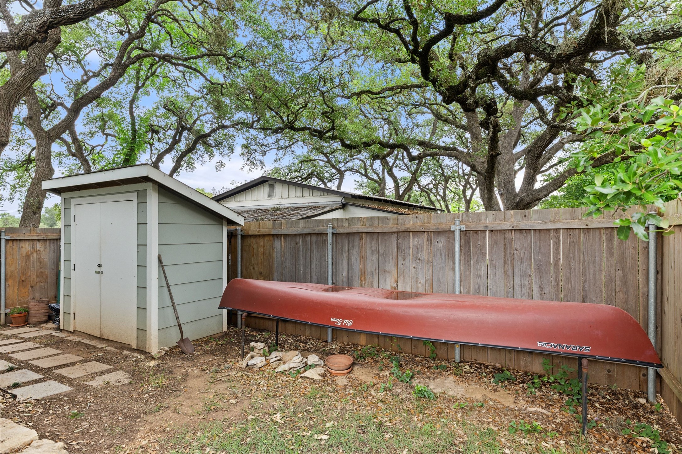 701 River Road Blanco, TX 78606 - Photo 32 of 38 a backyard of a house with a tree and wooden fence