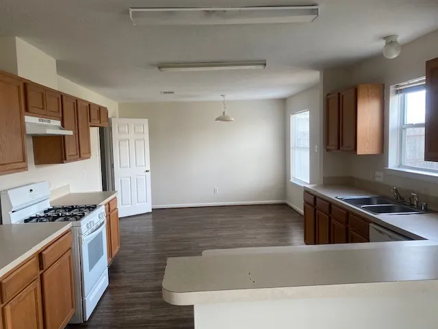 a kitchen with granite countertop a sink and a stove top oven