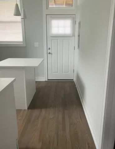a view of a hallway with wooden floor and staircase