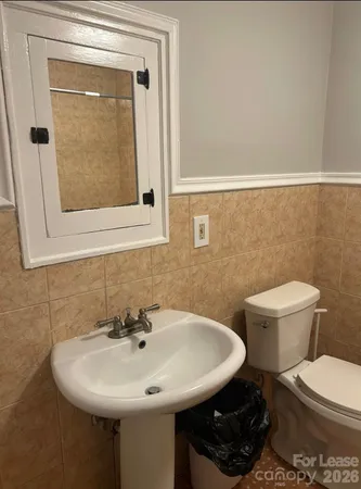 a bathroom with a sink a toilet and mirror
