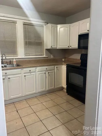 a kitchen with white cabinets a sink and dishwasher