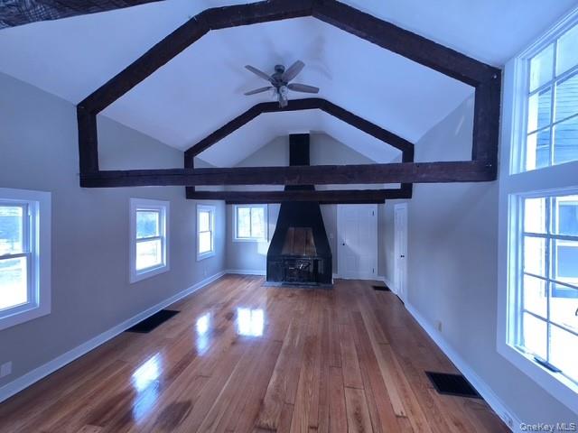 263 South Mountain Road New City, NY 10956 - Photo 18 of 33 Unfurnished living room with dark wood-type flooring, lofted ceiling, a wood stove, and ceiling fan