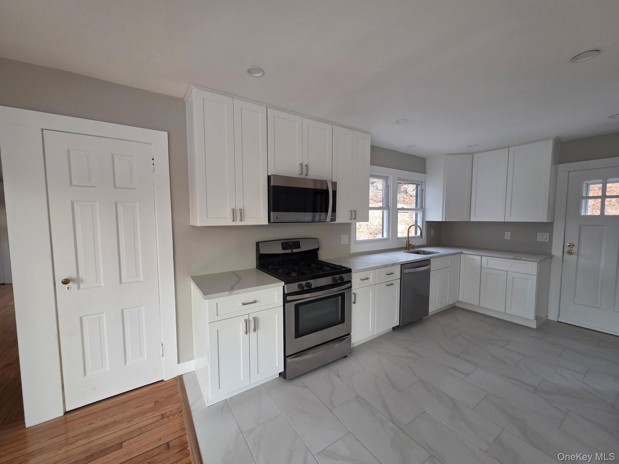 263 South Mountain Road New City, NY 10956 - Photo 7 of 13 Kitchen featuring appliances with stainless steel finishes, white cabinetry, and light marble finish floors
