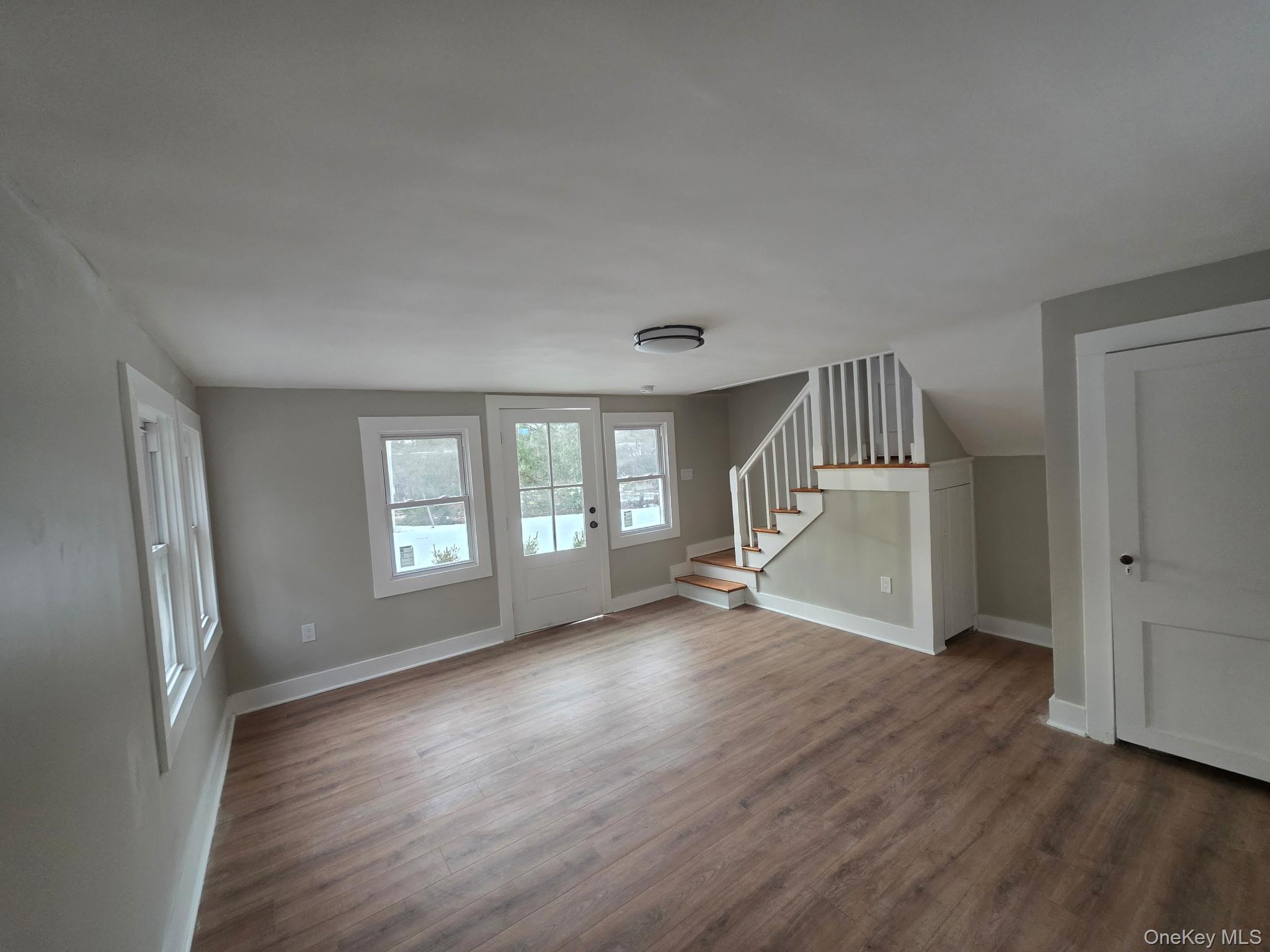 263 South Mountain Road New City, NY 10956 - Photo 8 of 33 Unfurnished living room featuring dark wood-style flooring and stairway