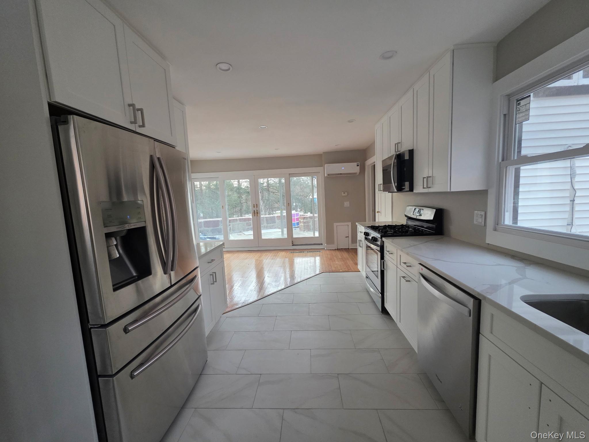 263 South Mountain Road New City, NY 10956 - Photo 9 of 33 Kitchen featuring white cabinets, appliances with stainless steel finishes, light stone countertops, and recessed lighting