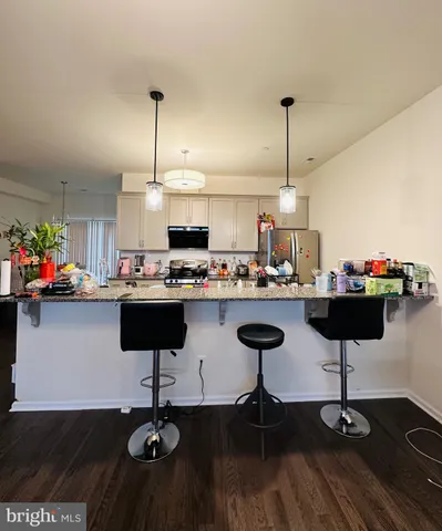 a kitchen with stainless steel appliances kitchen island granite countertop a table and chairs in it