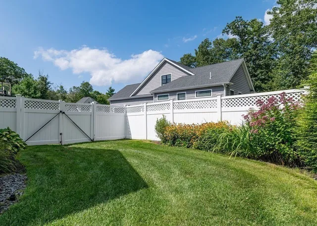 a house that is sitting in the grass with wooden fence