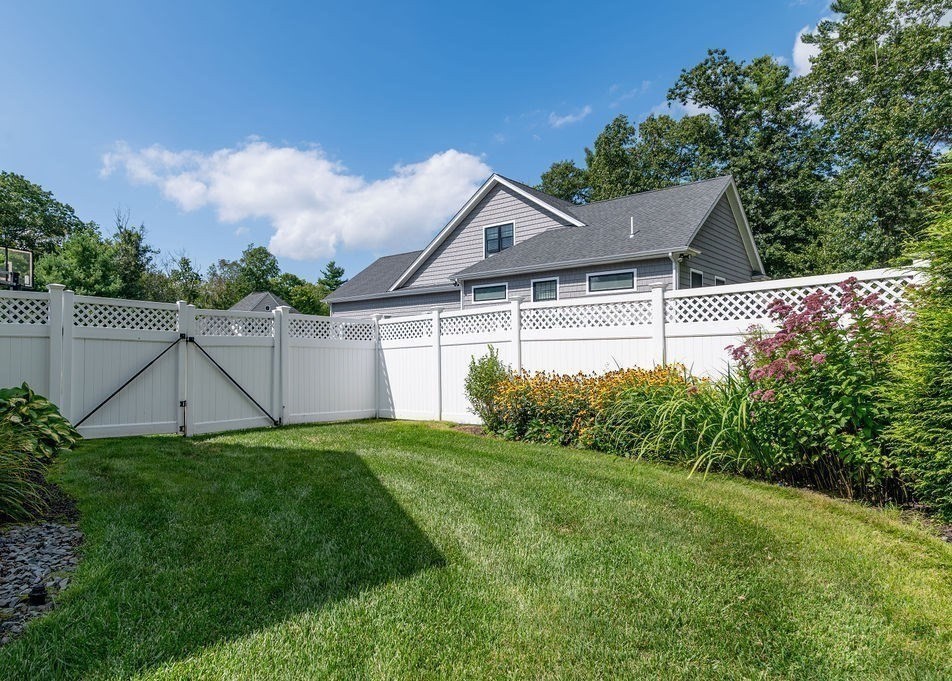 53 Queens Circle Raynham, MA 02767 - Photo 14 of 38 a house that is sitting in the grass with wooden fence