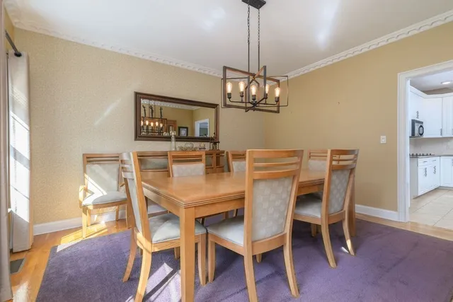 a dining room with furniture a chandelier and wooden floor