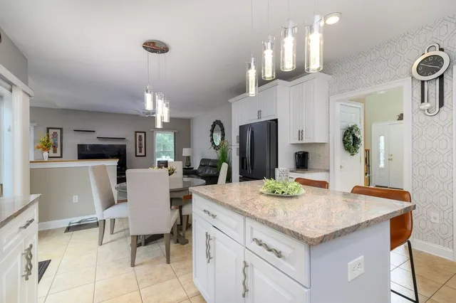a kitchen with kitchen island a stove a table and chairs in it