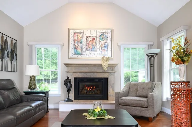 a living room with furniture large window and a fireplace