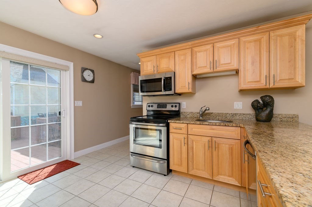 53 Queens Circle Raynham, MA 02767 - Photo 32 of 38 a kitchen with stainless steel appliances granite countertop a stove a sink and a microwave