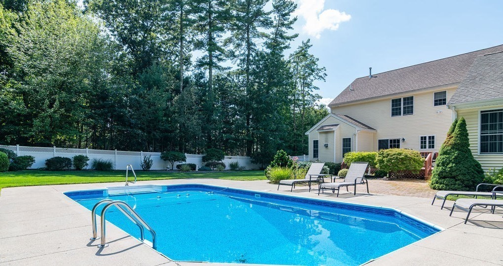 53 Queens Circle Raynham, MA 02767 - Photo 8 of 38 a view of a swimming pool with lawn chairs and plants