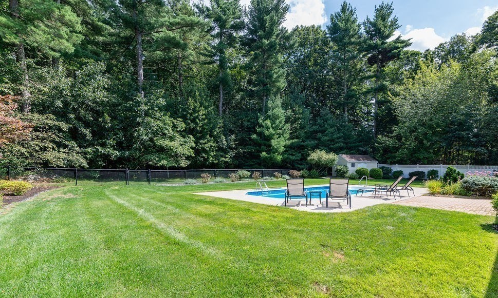 53 Queens Circle Raynham, MA 02767 - Photo 9 of 38 a view of a swimming pool with a bench and trees