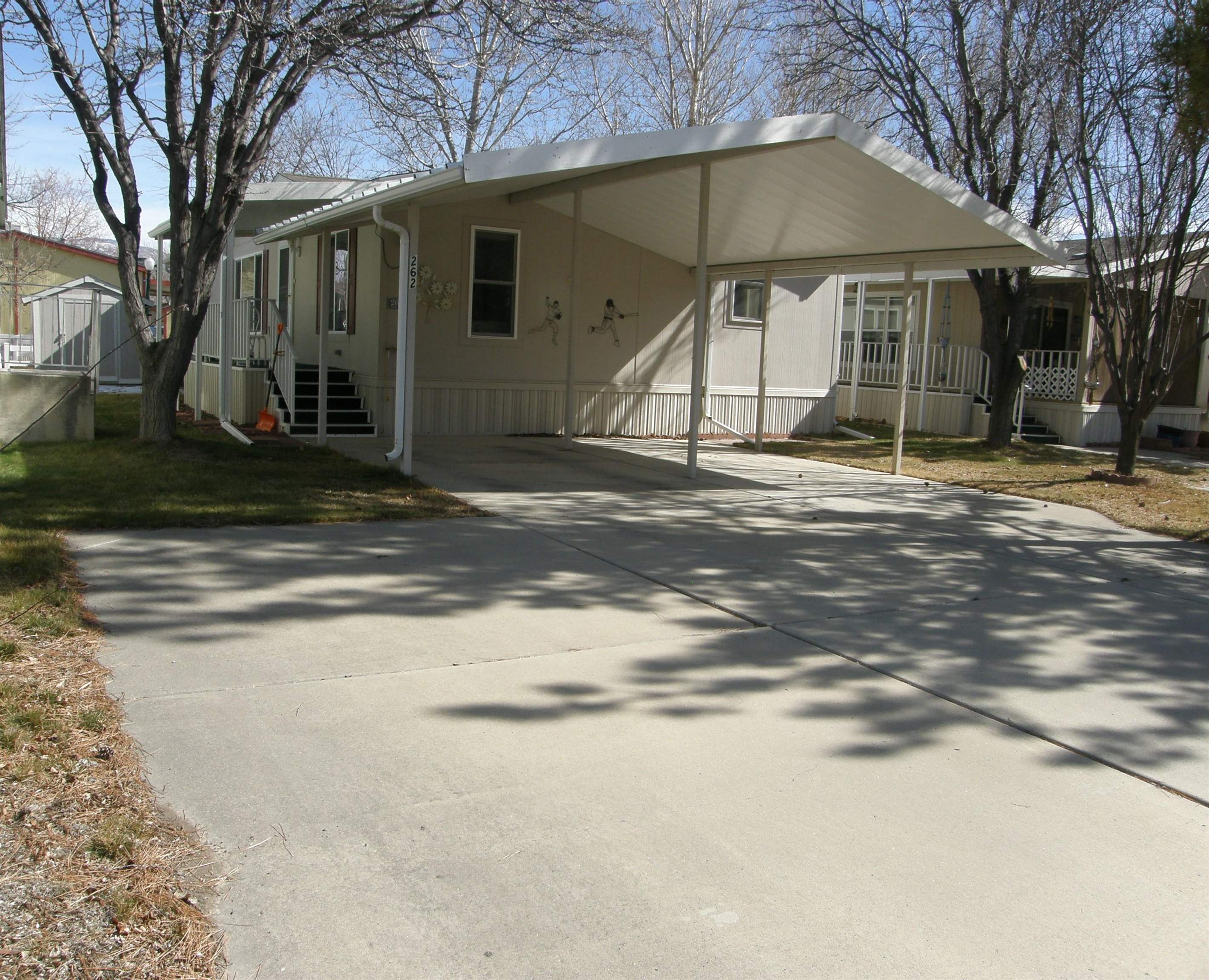 a backyard of a house with table and chairs under an umbrella