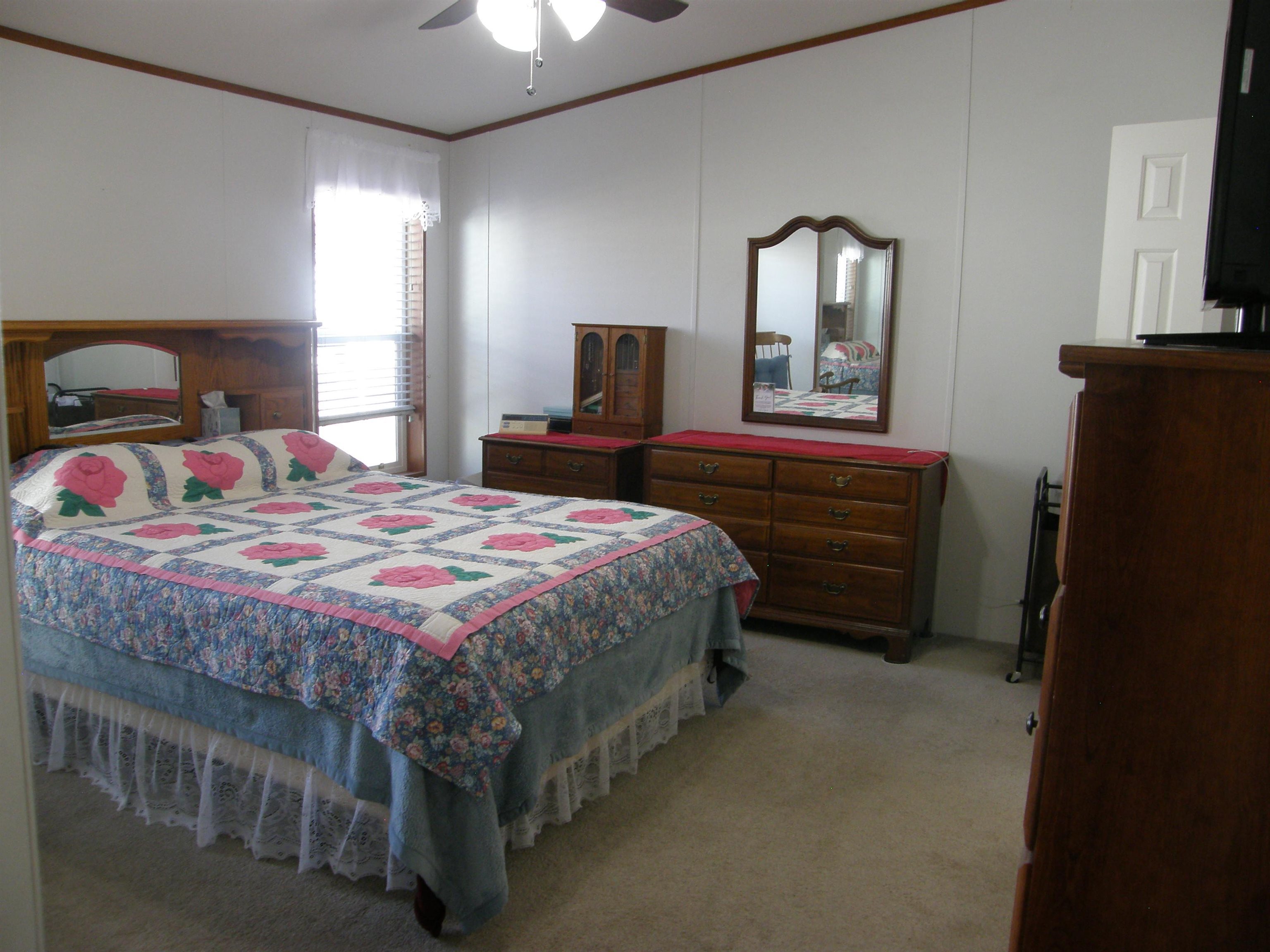 435 32 Road, Unit 262 Clifton, CO 81520 - Photo 25 of 42 a bedroom with a bed and a mirror on dresser