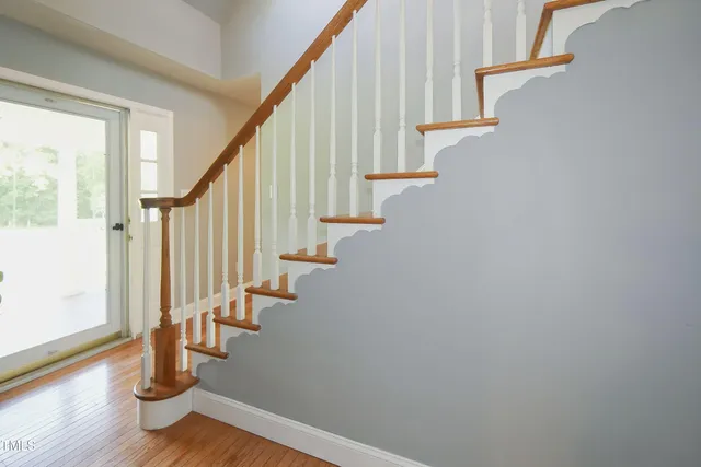 a view of a hallway with wooden floor and windows