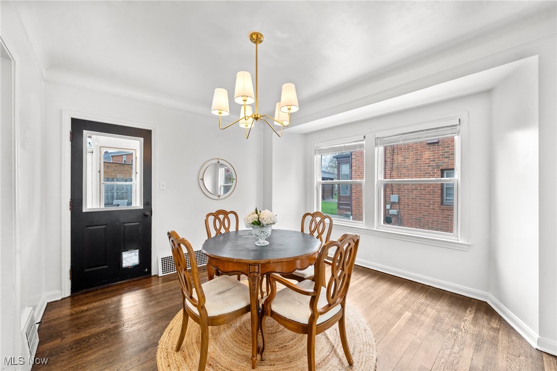2323 Saybrook Road Cleveland, OH 44118 - Photo 9 of 42 Dining area with an inviting chandelier, wood finished floors, visible vents, and baseboards