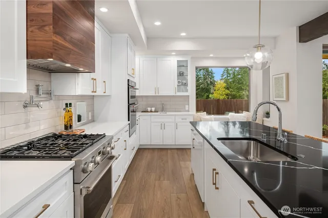 a kitchen with kitchen island granite countertop a sink stainless steel appliances and window