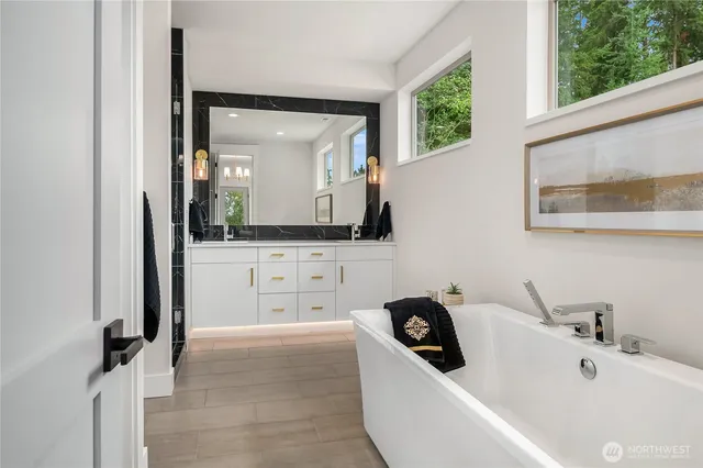a bathroom with a bathtub sink and mirror