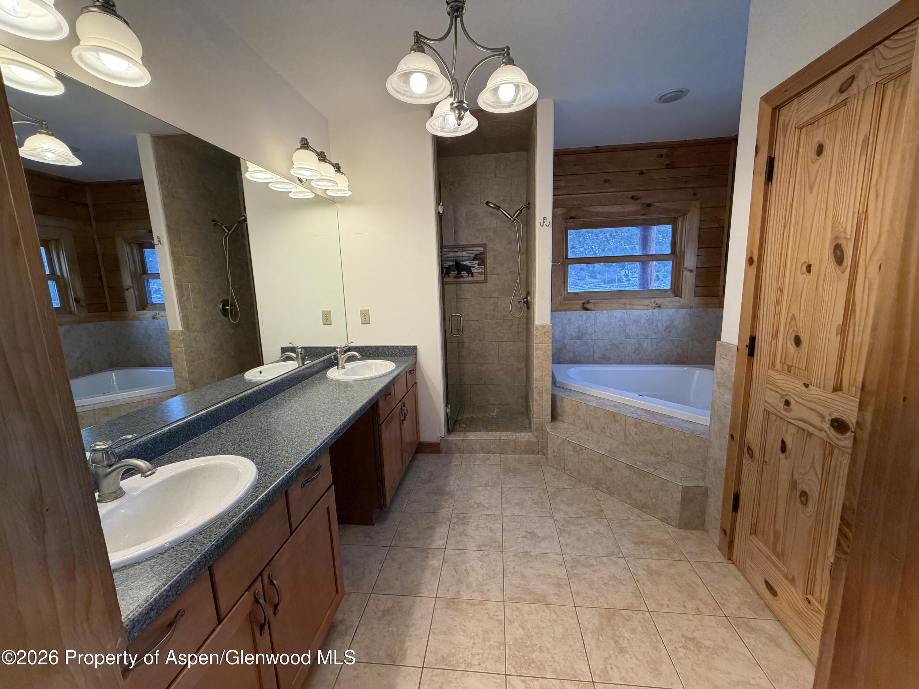 219 Big Dog Road Rifle, CO 81650 - Photo 7 of 11 a spacious bathroom with a granite countertop sink a mirror and shower