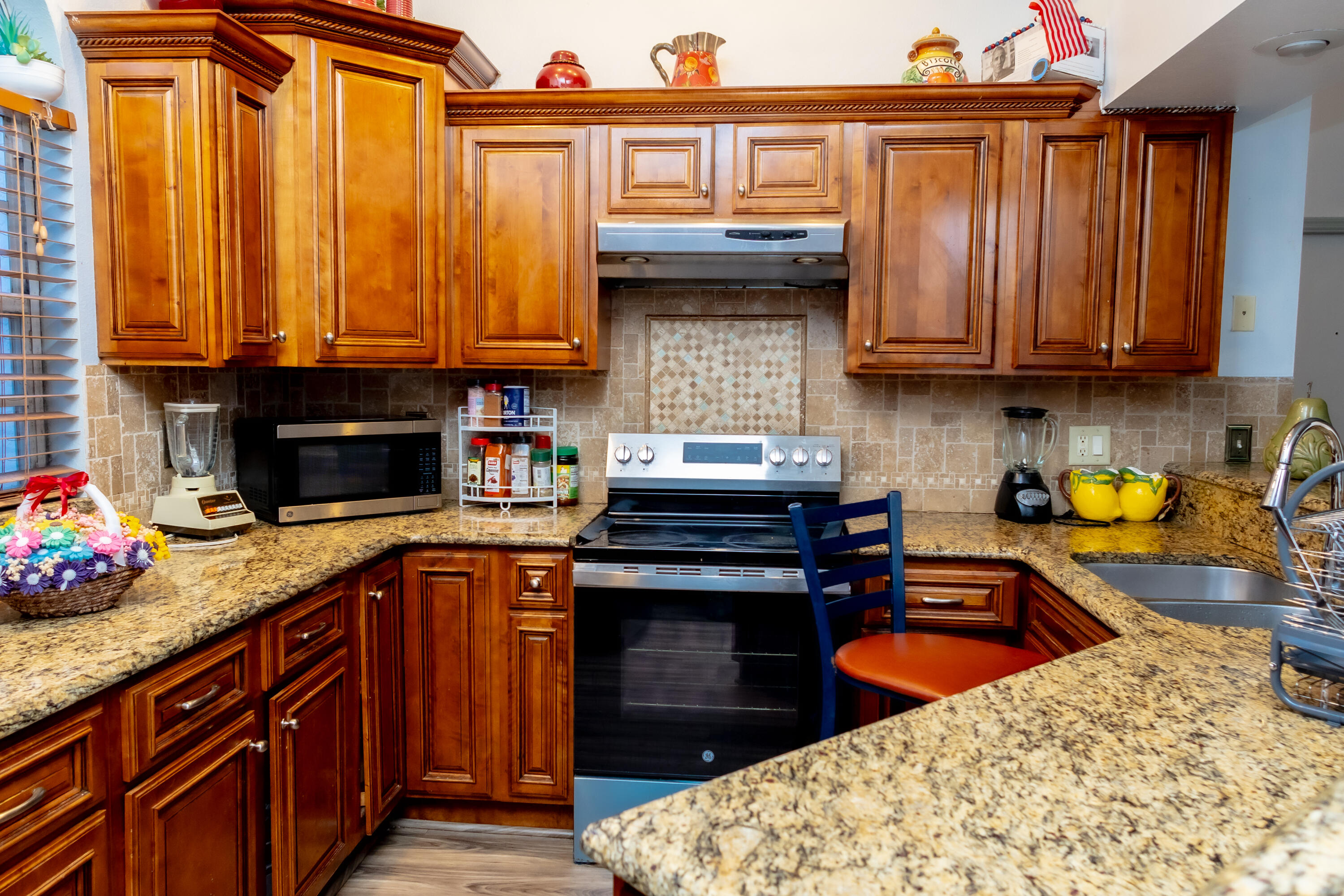 464 Emerald Cove Loop Lakeland, FL 33813 - Photo 9 of 25 a kitchen with granite countertop a stove a sink dishwasher and cabinets with wooden floor