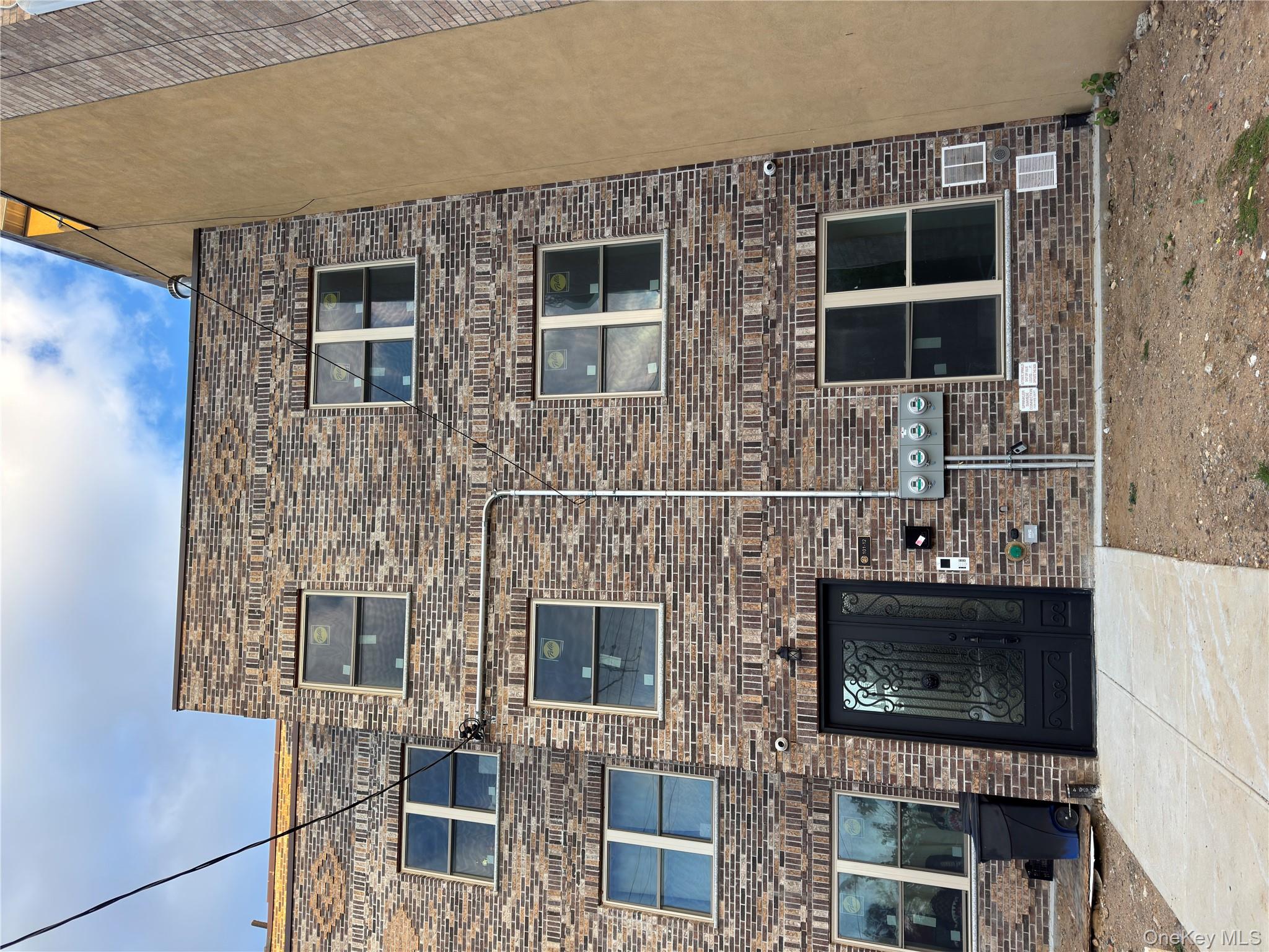 101-12 Martense Avenue Queens, NY 11368 - Photo 1 of 8 a brick building with a bench in front of it