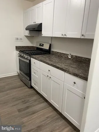 a kitchen with granite countertop white cabinets and stainless steel appliances