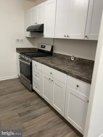 a kitchen with granite countertop white cabinets and stainless steel appliances