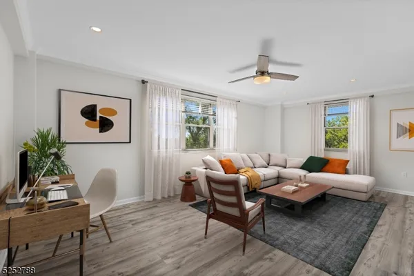 a living room with furniture two window and a potted plant