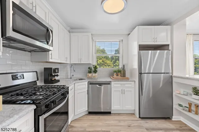 a kitchen with stainless steel appliances granite countertop a stove a refrigerator and a microwave