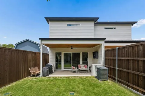 a view of a house with a patio and a yard