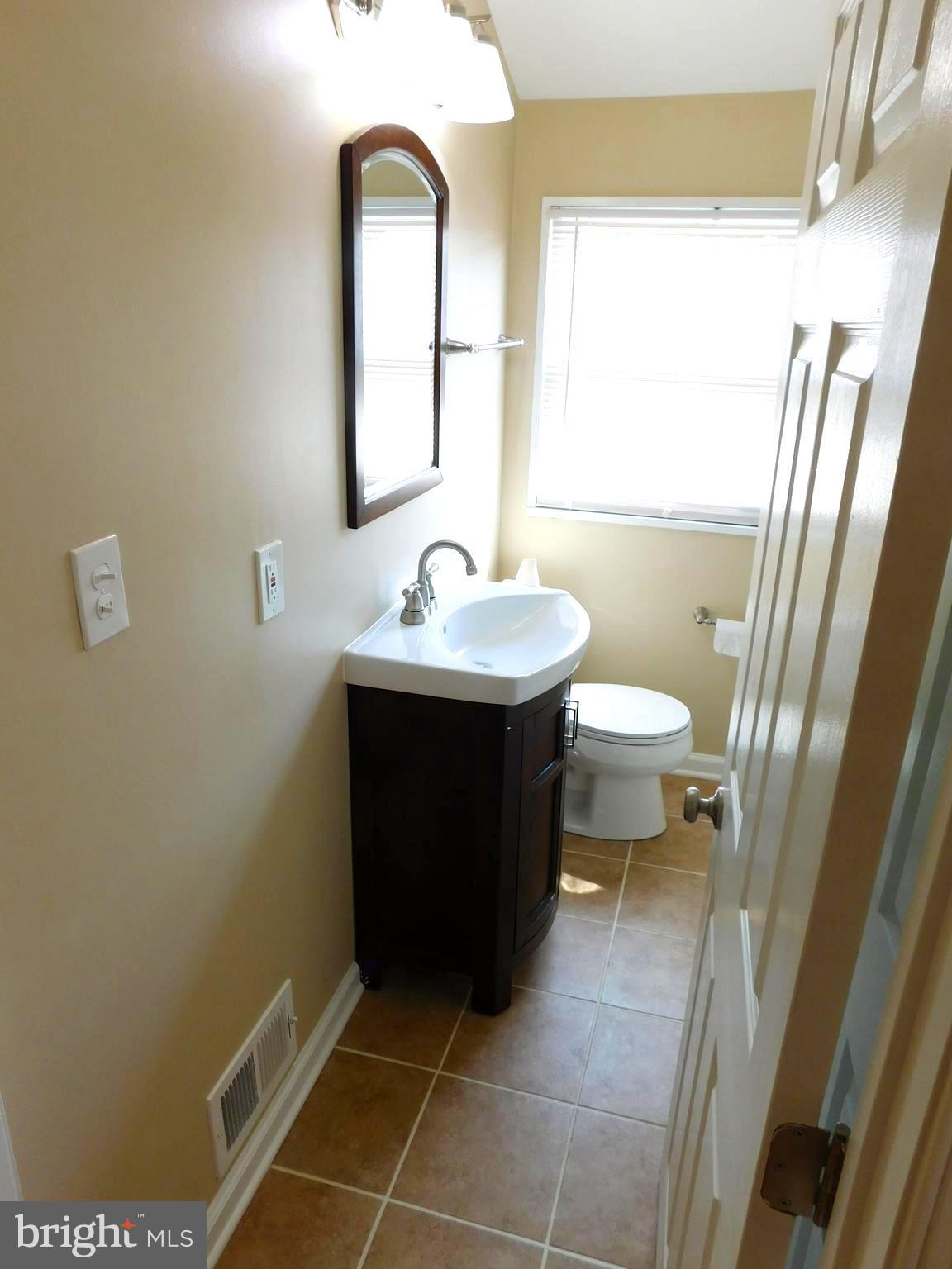 618 Brisbane Road Baltimore, MD 21229 - Photo 23 of 30 a bathroom with a sink a toilet and a mirror