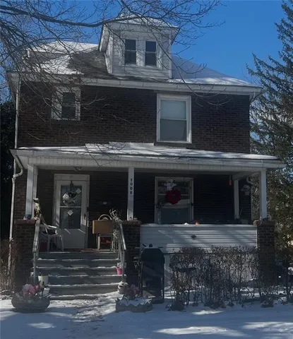 a view of a house with a large window and potted plants