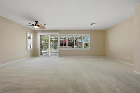 a living room with furniture a flat screen tv and large windows