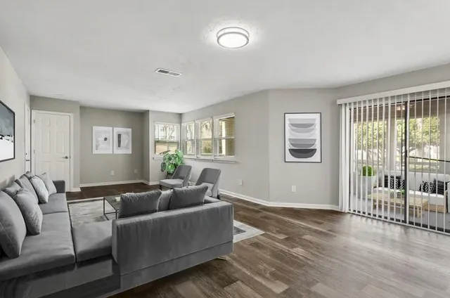 a living room with furniture and a window with balcony view
