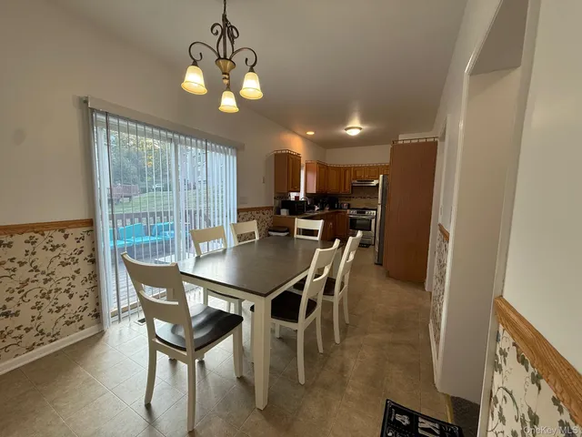 a view of a dining room with furniture and a chandelier