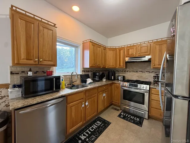 a kitchen with stainless steel appliances a stove sink and cabinets