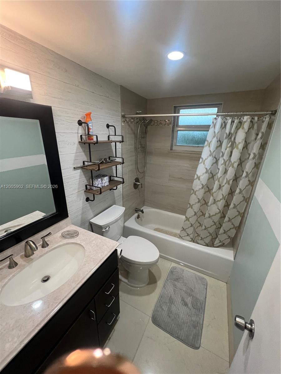 9945 Southwest 164th Terrace, Unit 1 Miami, FL 33157 - Photo 2 of 8 a bathroom with a double vanity sink toilet and shower