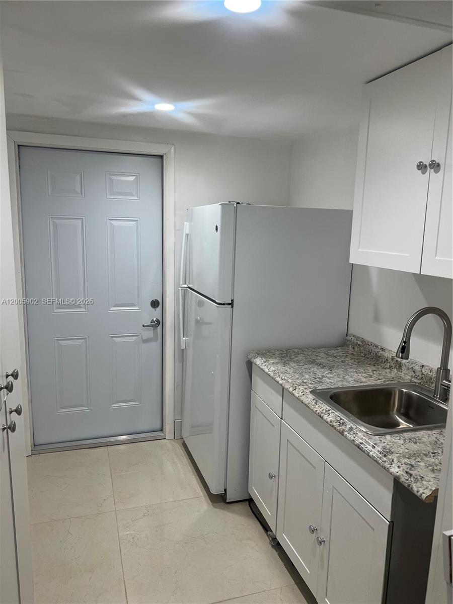 9945 Southwest 164th Terrace, Unit 1 Miami, FL 33157 - Photo 3 of 8 a kitchen with stainless steel appliances granite countertop a sink and refrigerator