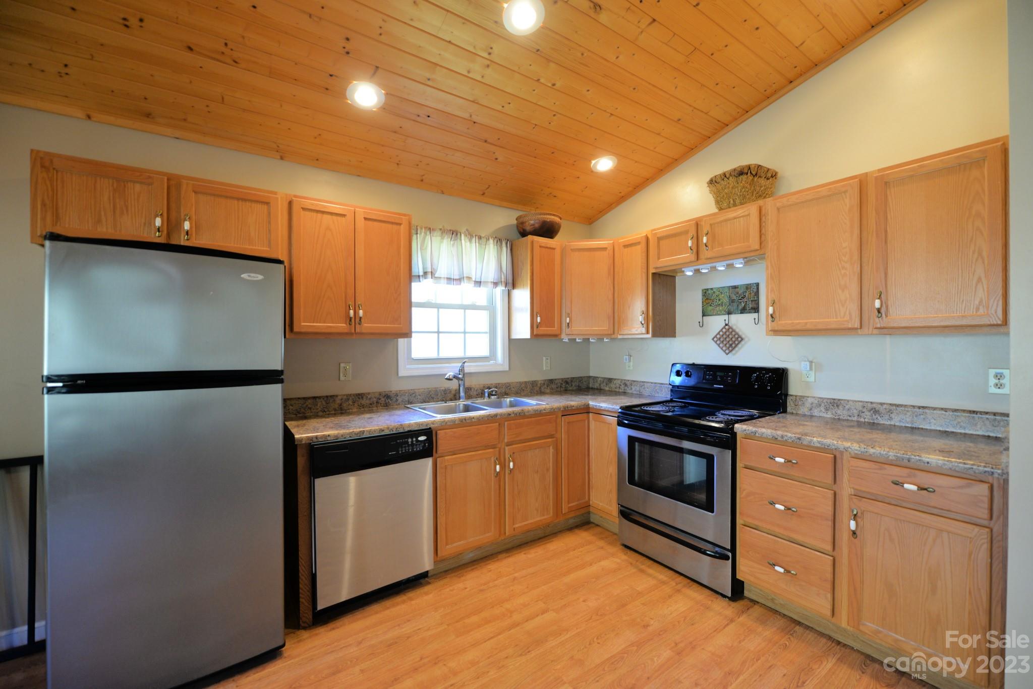 99 Bayside Drive Sylva, NC 28779 - Photo 13 of 34 a kitchen with stainless steel appliances granite countertop a stove a sink dishwasher a refrigerator and a microwave