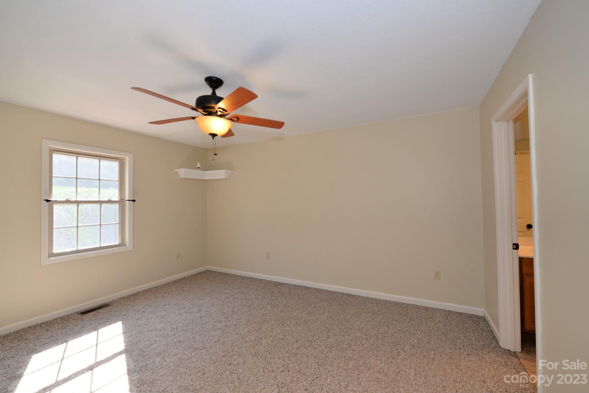 99 Bayside Drive Sylva, NC 28779 - Photo 21 of 34 an empty room with chandelier fan and window