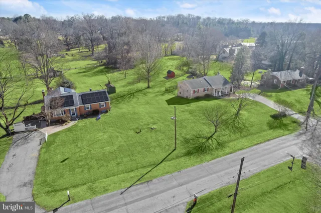 a view of a big building with a big yard and large trees