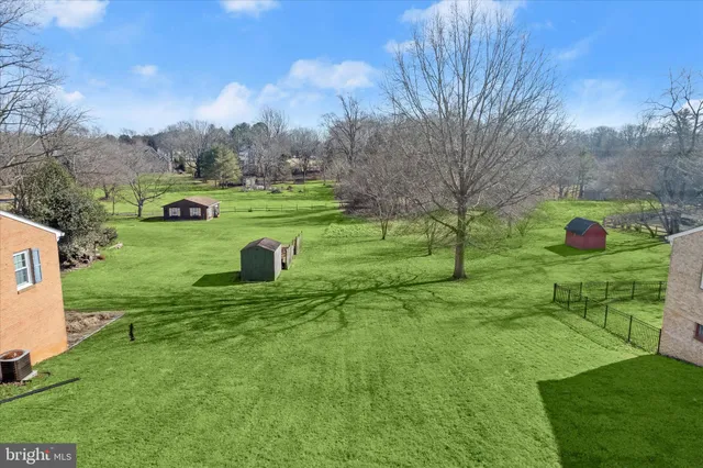 a view of a house with a big yard and palm trees