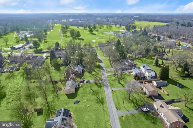a view of a lush green field with lots of trees