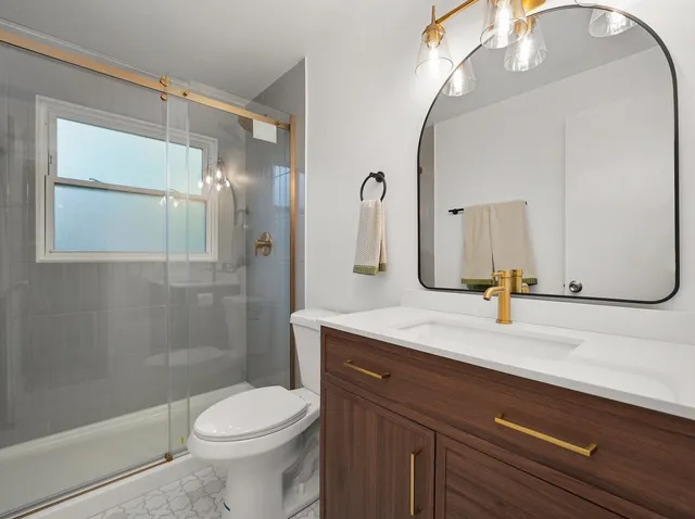 a bathroom with a sink a toilet and shower