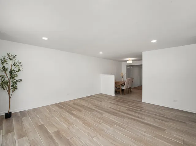 a view of empty room with wooden floor and entryway