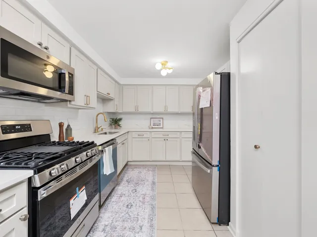 a kitchen with stainless steel appliances a refrigerator a stove top oven and sink